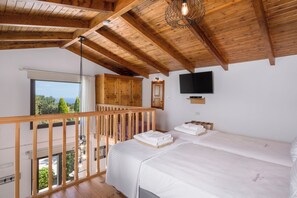 A bedroom with a large bed, a television, and a balcony with a view. - Villa Freedom | A Private Luxury Estate in the Heart of Crete (Chania)