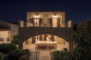 A stone building with a covered patio and a dining area. - Villa Freedom | A Private Luxury Estate in the Heart of Crete (Chania)