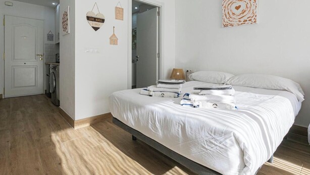 Ein Schlafzimmer mit einem Bett, einer Nachttischlampe und einer Wand mit Dekoration.