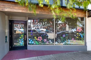 A storefront with a large window displaying a floral design and the words 'Steak, Seafood, Pasta, Desserts'. - Bay View Dunes Getaway (North Bend)