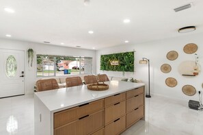 A modern kitchen with a central island, wooden cabinets, and a view of the outside. - Tampa Pool Oasis, Lux Boho Design, , Otdr Movie & Kitchen, Near Golf (Tampa)