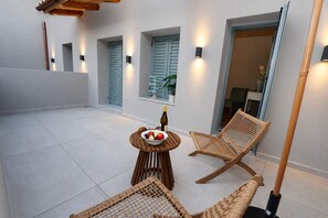 Ein Balkon mit Tisch, Korbstühlen und einer Obstschale.