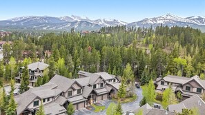 A residential area with multiple houses, surrounded by dense forest and mountains in the background. - Walk to Gondola | Mountain Thunder Townhome Retreat (Breckenridge)