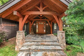 A wooden cabin with a stone staircase leading to a wooden door. - Bottle Bay Lakefront Lodge | Dock & Game Room (Sagle)