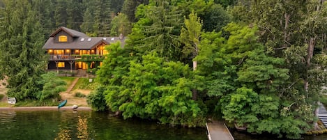 A lakeside cabin with a dock extending into the water.