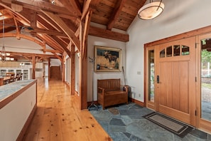 A wooden interior with a stone floor, a bench, a door, and a painting of a moose. - Bottle Bay Lakefront Lodge | Dock & Game Room (Sagle)