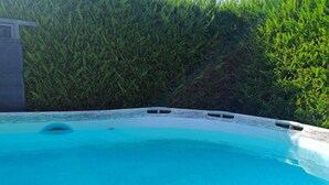 Piscina com borda de pedra e uma pequena abertura circular.