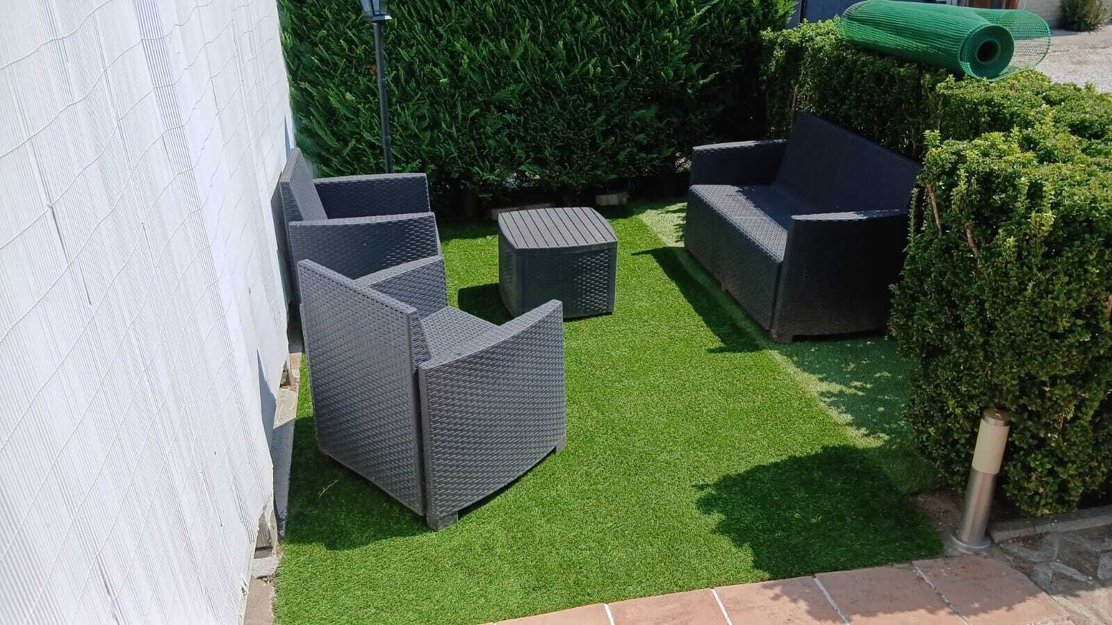 A patio area with outdoor furniture and artificial grass.