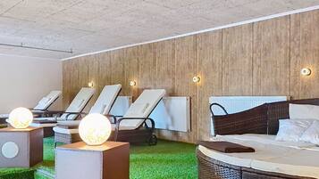 A room with a bed, a massage chair, and a massage table.
