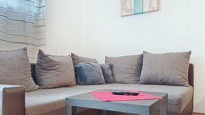 Una sala de estar con un sofá, una mesa de centro y un cuadro en la pared.