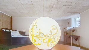 Una stanza con un tavolo rotondo, un oggetto decorativo, un letto e una finestra.