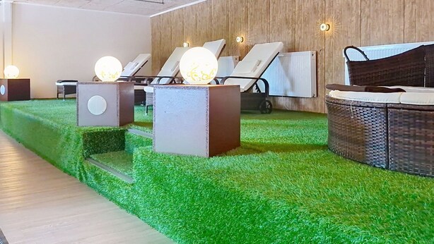 Un'area benessere con poltrone relax, un lettino da massaggio e un termosifone a parete.