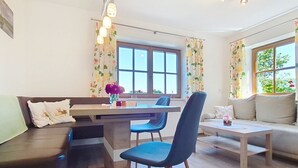 Un salon moderne comprenant un coin repas, un canapé, une table basse et une fenêtre avec des rideaux.