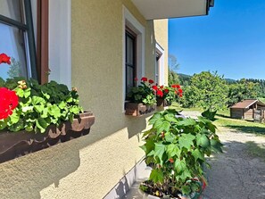 A building with a beige exterior, a window with a flower box, and a clear sky. - Beautiful apartment for 4 guests with WIFI, TV and terrace (Oberwang)