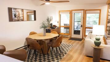 A dining area with a round table, chairs, and a checkered rug.
