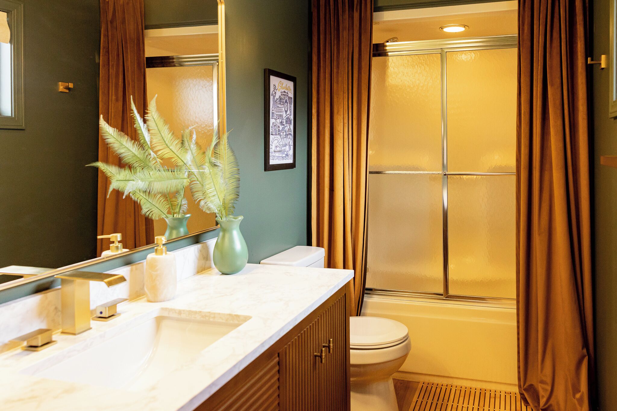 A bathroom with a white sink, a toilet, and a shower with frosted glass doors.