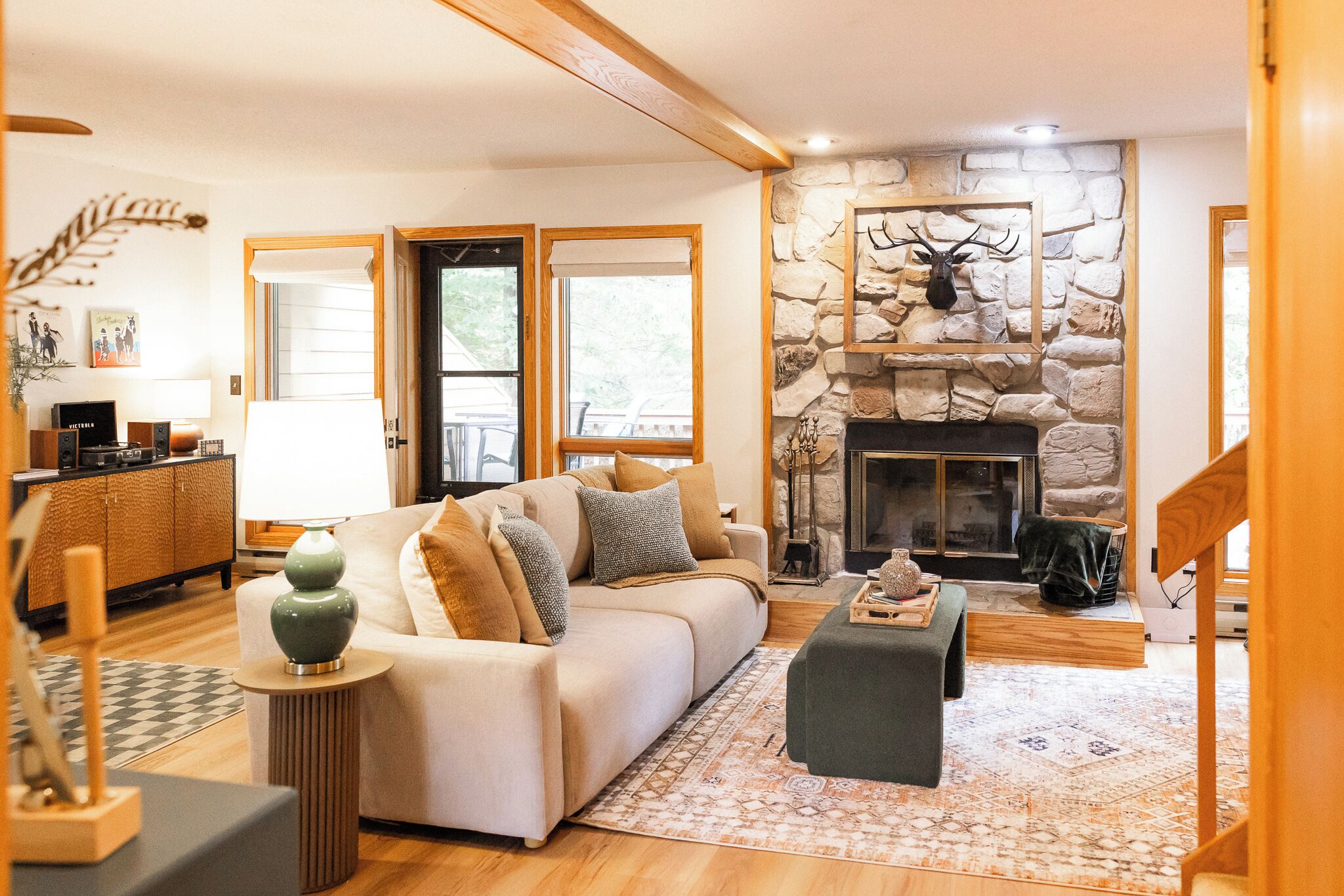 A cozy living room with a stone fireplace, a sofa, and a coffee table.