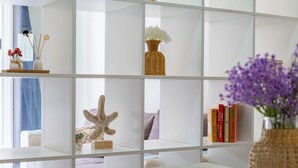 Uma estante branca com objetos decorativos e livros.