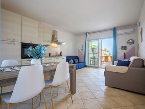 Eine moderne Küche mit Essbereich, einer Couch und Blick ins Freie.