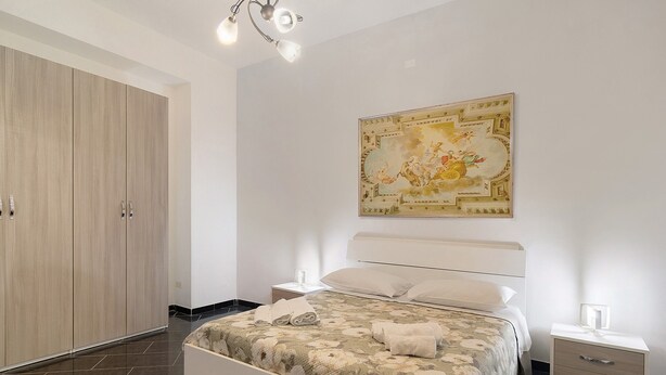 Una camera da letto con un letto, comodini, un armadio e una lampada a soffitto.