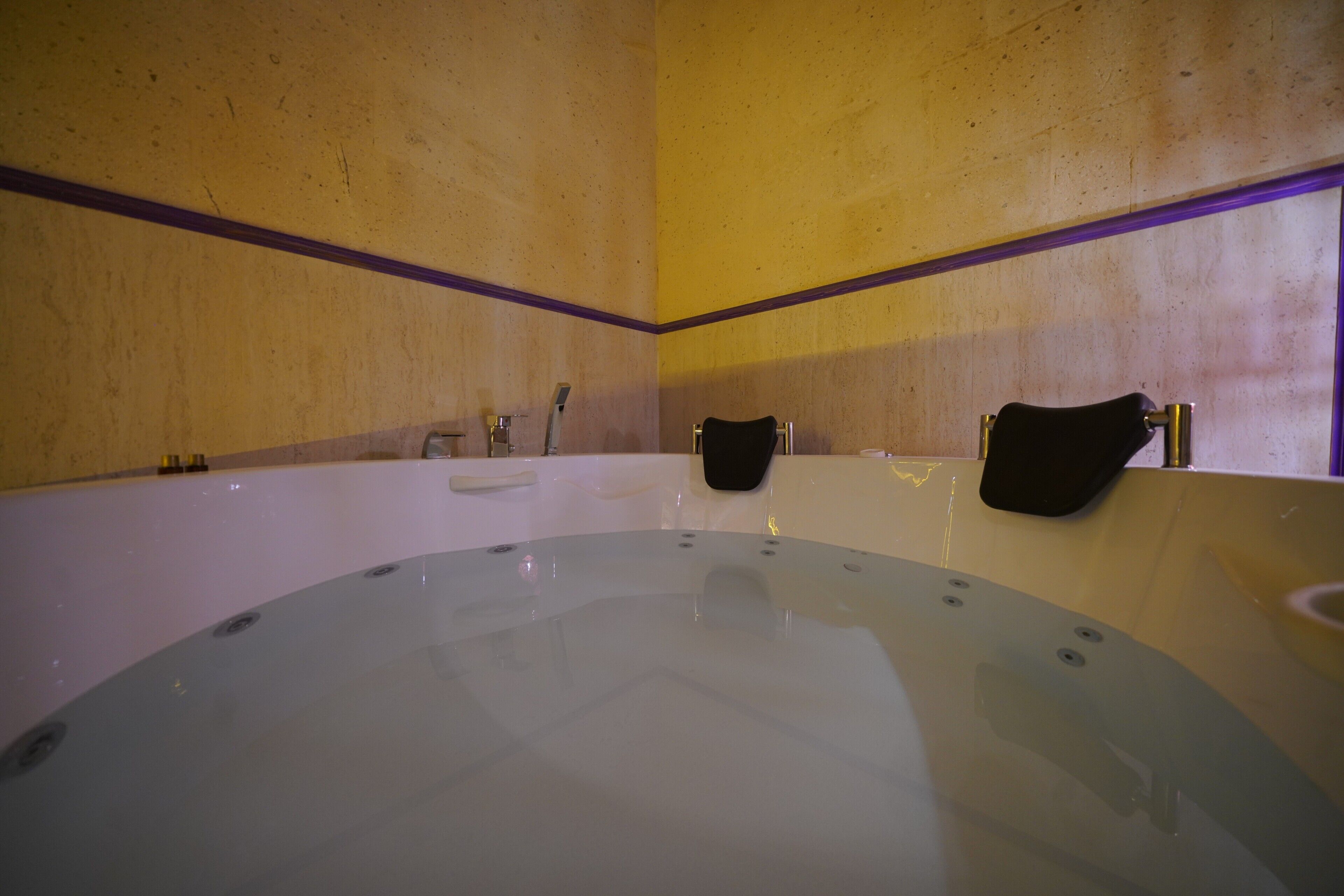 A bathroom with a large bathtub, a towel rack, and a sink.