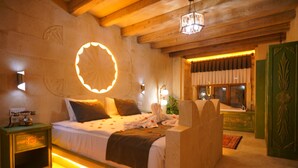 A bedroom with a bed, bedside tables, a mirror, and a window with curtains. - Uçhisar Palace in Cappadocia Hotel (Nevsehir)
