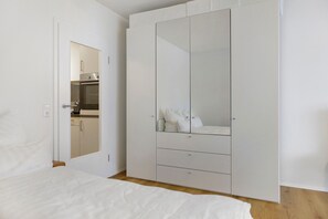Ein Schlafzimmer mit einem Bett, einem Kleiderschrank und einem Spiegel.