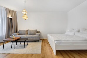 Ein modernes Schlafzimmer mit einem Bett, einer Couch, einem Couchtisch und einer Stehlampe.