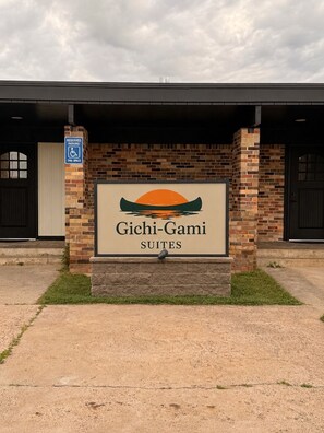 Letrero de Gichi-Gami Suites con un diseño de canoa y atardecer.