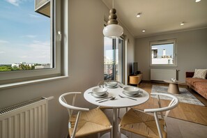 Una sala de estar moderna con comedor, ventanas amplias y vista a la ciudad.