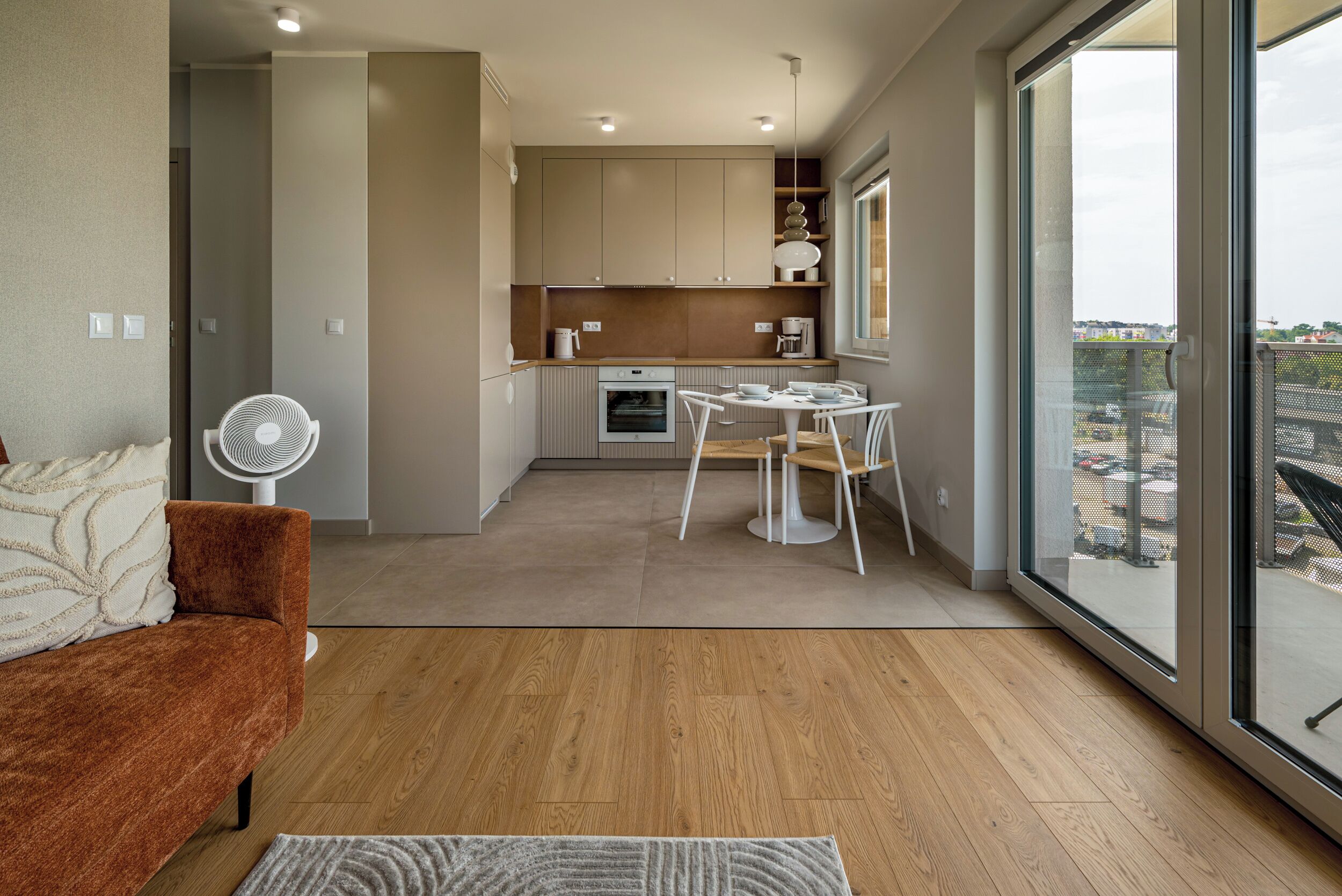A modern kitchen with a dining area, a large window, and a view of the city.