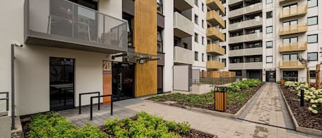 Moderni, useita kerroksia korkea asuinkerrostalo, jossa on parvekkeet, portilla varustettu sisäänkäynti ja maisemoitu sisäpiha.