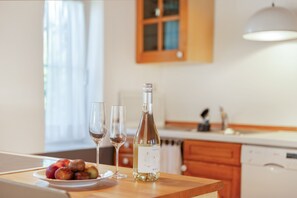 A kitchen counter with a bottle of wine, two glasses, and a plate of fruit. - Vacation home 'am quittenbaum', family vacation on Lake Constance (Überlingen)