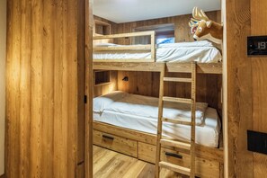 Ein Schlafraum mit Etagenbetten, Holzwänden und einer an der Decke befestigten Leuchte.