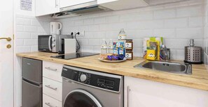 A compact kitchen with a microwave, toaster, and a washing machine. - 'El Ciaboga' Apartment with Wi-Fi and Air Conditioning (Torremolinos)