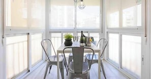 A dining area with a table and chairs, a potted plant, and a bottle of wine. - 'El Ciaboga' Apartment with Wi-Fi and Air Conditioning (Torremolinos)