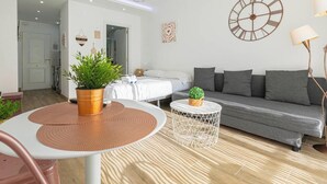 A modern living room with a sofa, a round coffee table, a side table, and a potted plant. - 'El Ciaboga' Apartment with Wi-Fi and Air Conditioning (Torremolinos)