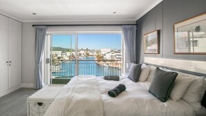 Habitación de hotel con una cama grande, vista a una piscina y un balcón.