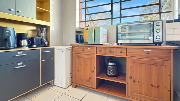 A kitchen with a built-in oven, a coffee maker, and a blender.