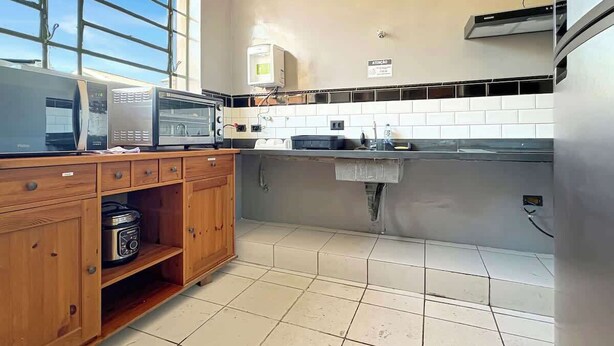 Una cucina con forno a microonde, fornelli e mobili in legno.