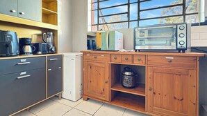 Una cucina con forno a incasso, macchina da caffè e frullatore sul piano di lavoro.