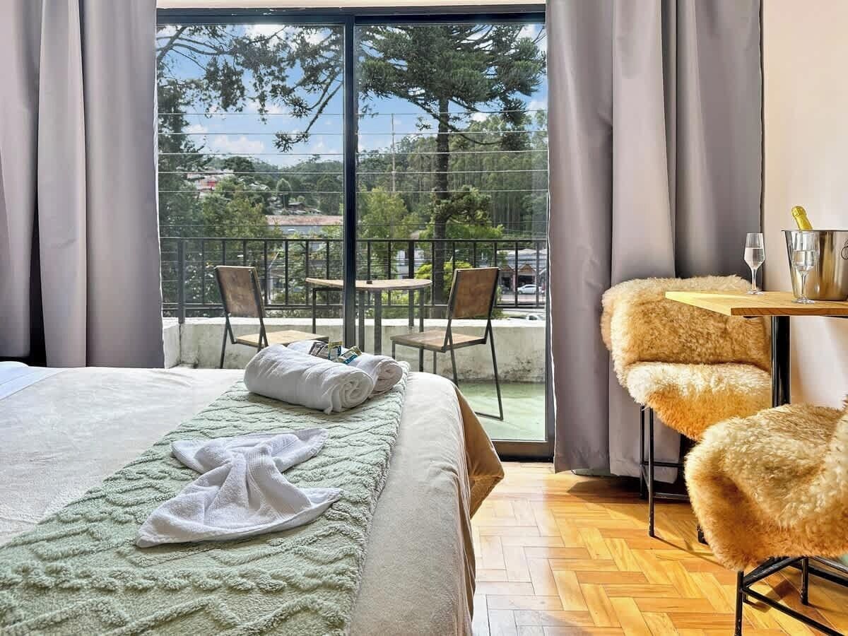 Una habitación de hotel con una cama, una mesa y sillas, y vistas al exterior.