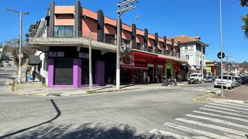 A street corner with a building featuring a ground-level commercial space and upper residential units.