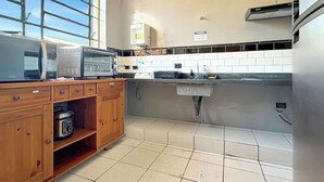 A kitchen with a microwave, toaster, and a wooden cabinet with a radio.
