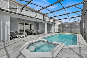Ein Innenpool mit Whirlpool, Liegestühlen und einer überdachten Terrasse.