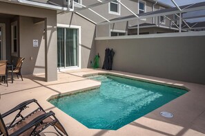 A swimming pool with a sunshade, a chair, and a hose. - Last Minute Disney Getaway! Private Pool & Themed Bedrooms. Book Now! #107645 (Orlando)