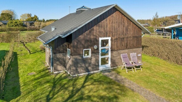 A single-story building with a sloped roof, a front door, and two small windows. - 5 Star Holiday Home in Svendborg (Svendborg)