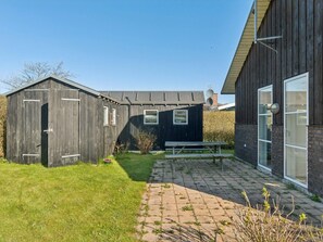 A building with a wooden exterior, a brick patio, and a bench. - 5 Star Holiday Home in Svendborg (Svendborg)
