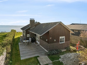 A wooden house with a deck and a view of the sea. - 5 Star Holiday Home in Svendborg (Svendborg)