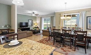A living room with a dining area, a ceiling fan, and a television. - Last Minute Disney Getaway! Luxury Villa with Private Pool. Book Now! #107669 (Orlando)